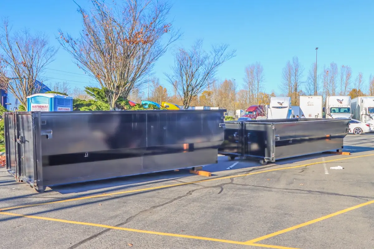 Professional dumpster rental service with roll-off container on residential driveway in Honeygo